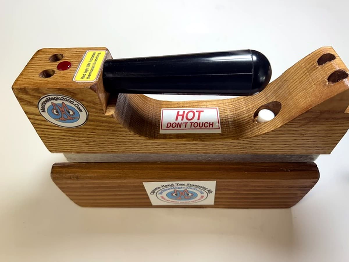 MM 7DLX Deluxe solid bar iron with polished brass bar resting in its wooden stand